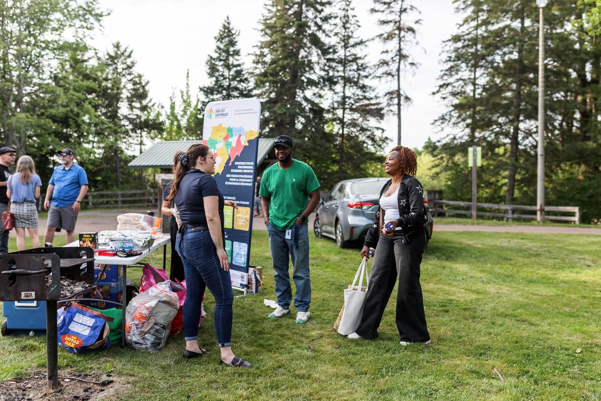 Une employée et des participants d'un BBQ de développement économique ont une conversation