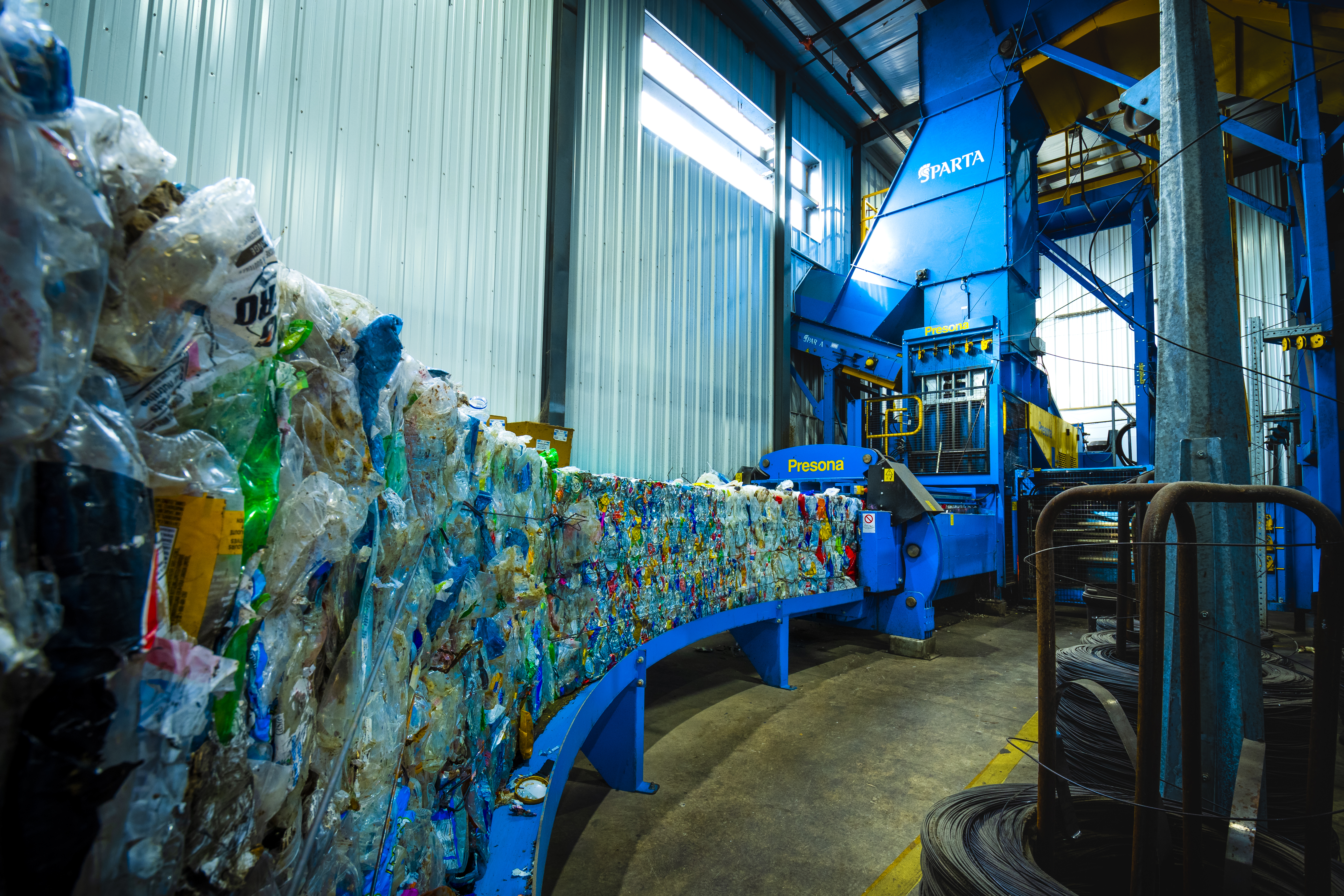 Une série de balles de matières recyclable sortant de la presse à balles