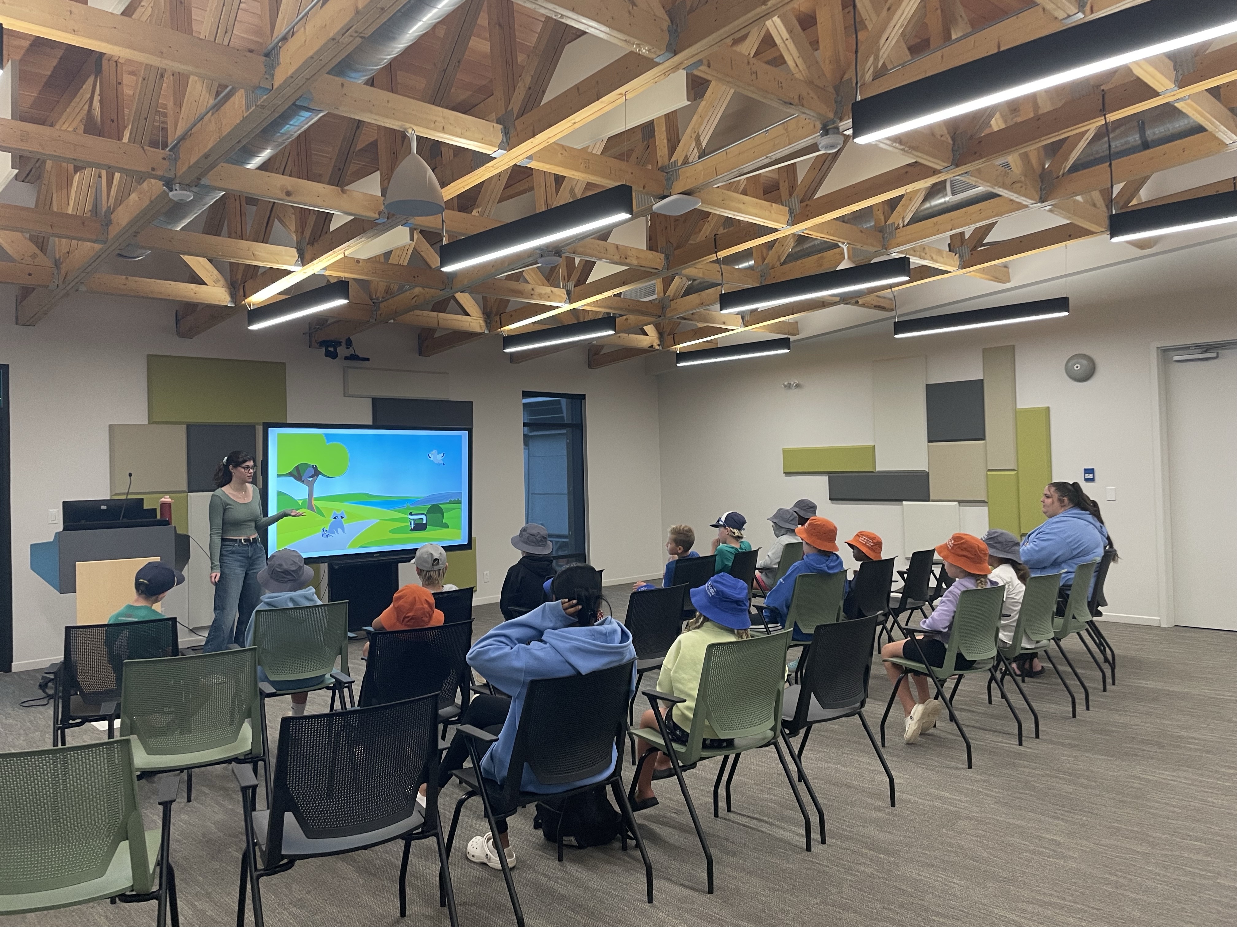 An educator in front of a screen teaching about recycling before a tour of the landfill